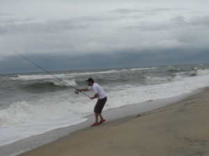 Photo of Lawrence casting into the surf
